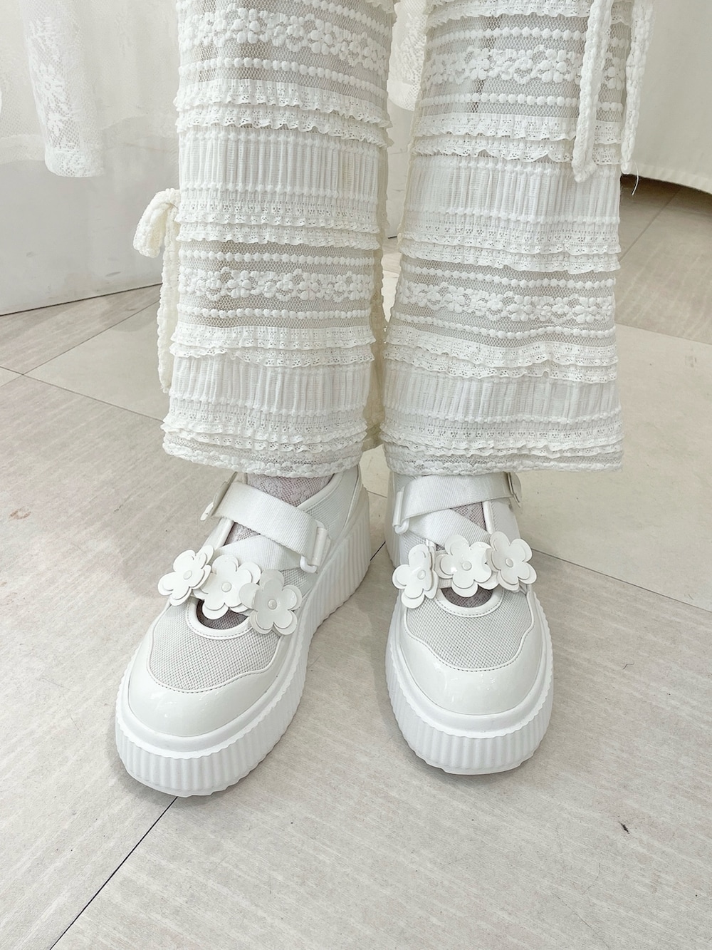 ホワイト系のスウェット、ホワイト系のスカート、ホワイト系のスニーカーを着用したレディースの冬コーディネートの8枚目の写真