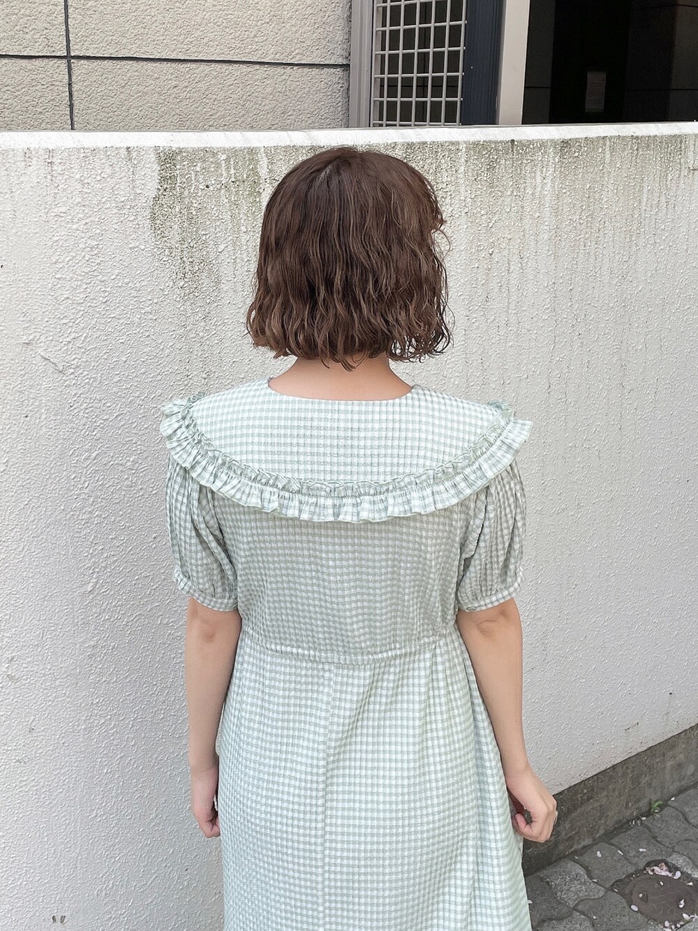 グリーン系のワンピース、ホワイト系のトートバッグ、ホワイト系のサンダルを着用したレディースの春コーディネートの7枚目の写真