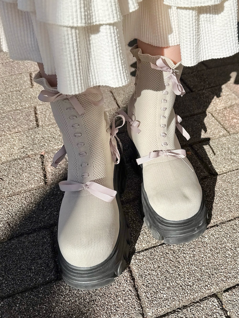 ピンク系のスウェット、ホワイト系のTシャツ/カットソー、ホワイト系のスカートを着用したレディースの冬コーディネートの9枚目の写真