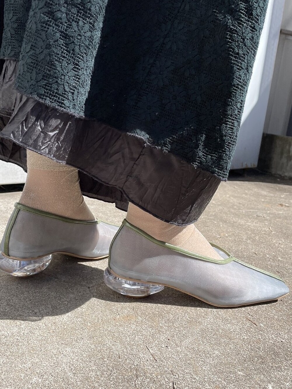 ブラック系のワンピース、ブルー系のパンプス、グレー系のTシャツ/カットソーを着用したレディースの春コーディネートの4枚目の写真