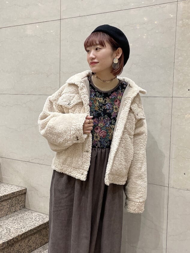 ブラック系のブーツ、ホワイト系のニット/セーター、ホワイト系のカバーオールを着用したレディースの冬コーディネートの3枚目の写真