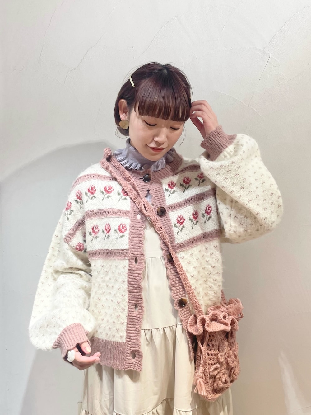 ピンク系のカーディガン/ボレロ、ホワイト系のワンピース、ブラウン系のパンプスを着用したレディースの冬コーディネートの3枚目の写真