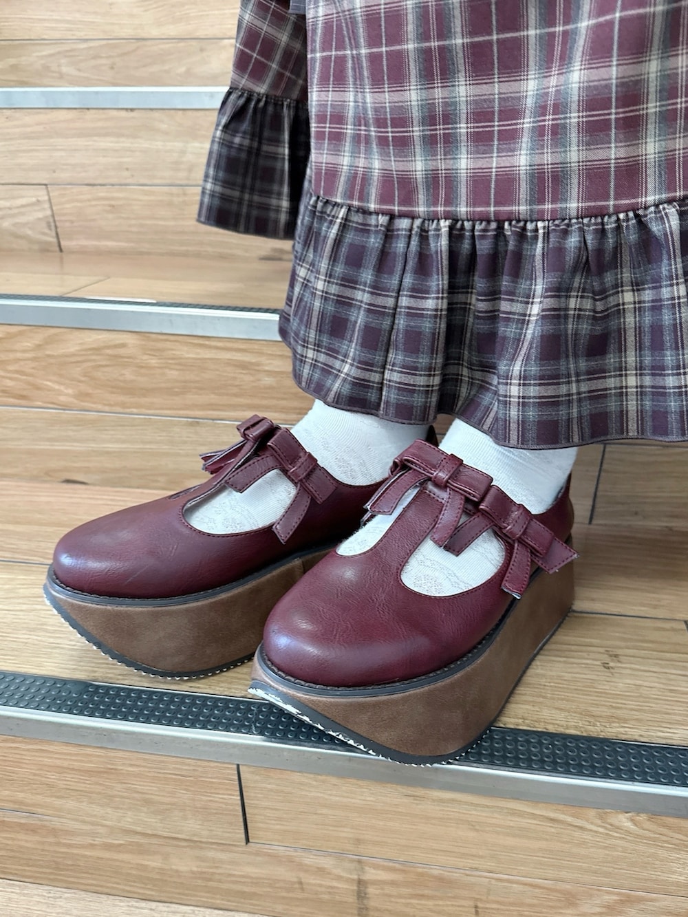 ブラウン系のニット/セーター、レッド系のワンピース、ベージュ系のハンドバッグを着用したレディースの秋コーディネートの8枚目の写真