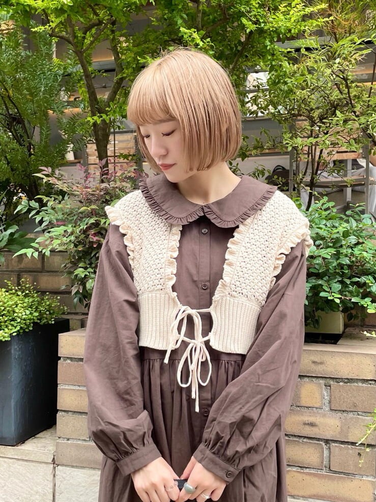 ベージュ系のハンドバッグ、ホワイト系のニット/セーター、ブラウン系のワンピースを着用したレディースの秋コーディネートの3枚目の写真