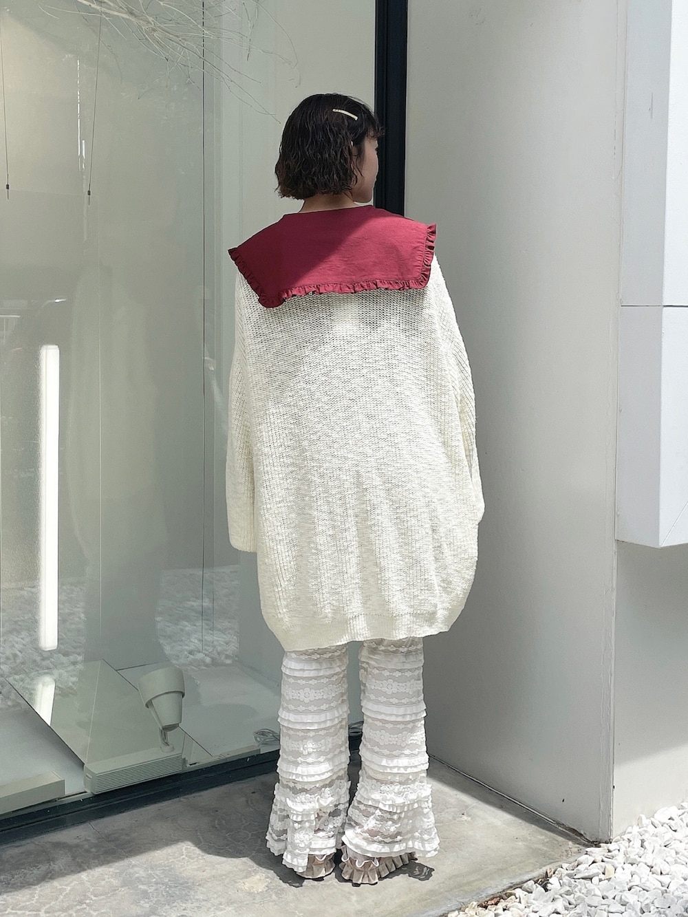 レッド系のワンピース、ホワイト系のカーディガン/ボレロ、ホワイト系のスウェットパンツを着用したレディースの夏コーディネートの3枚目の写真