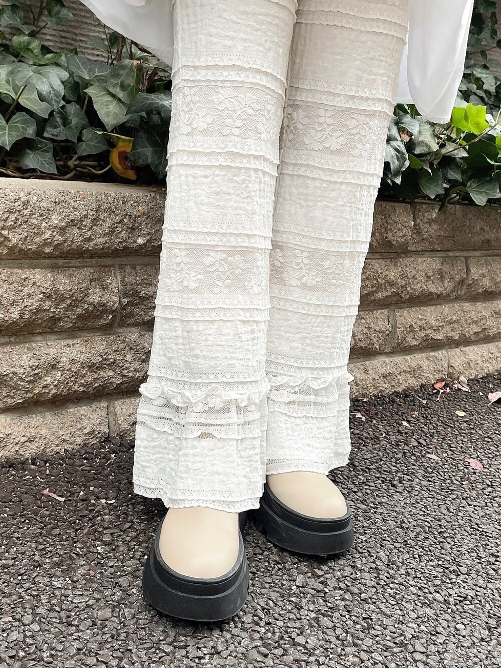 ホワイト系のワンピース、ホワイト系のスラックス、ベージュ系のブーツを着用したレディースの冬コーディネートの6枚目の写真