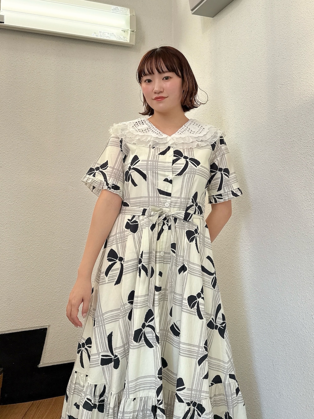 ホワイト系のワンピース、ブラック系のスニーカーを着用したレディースの冬コーディネートの4枚目の写真