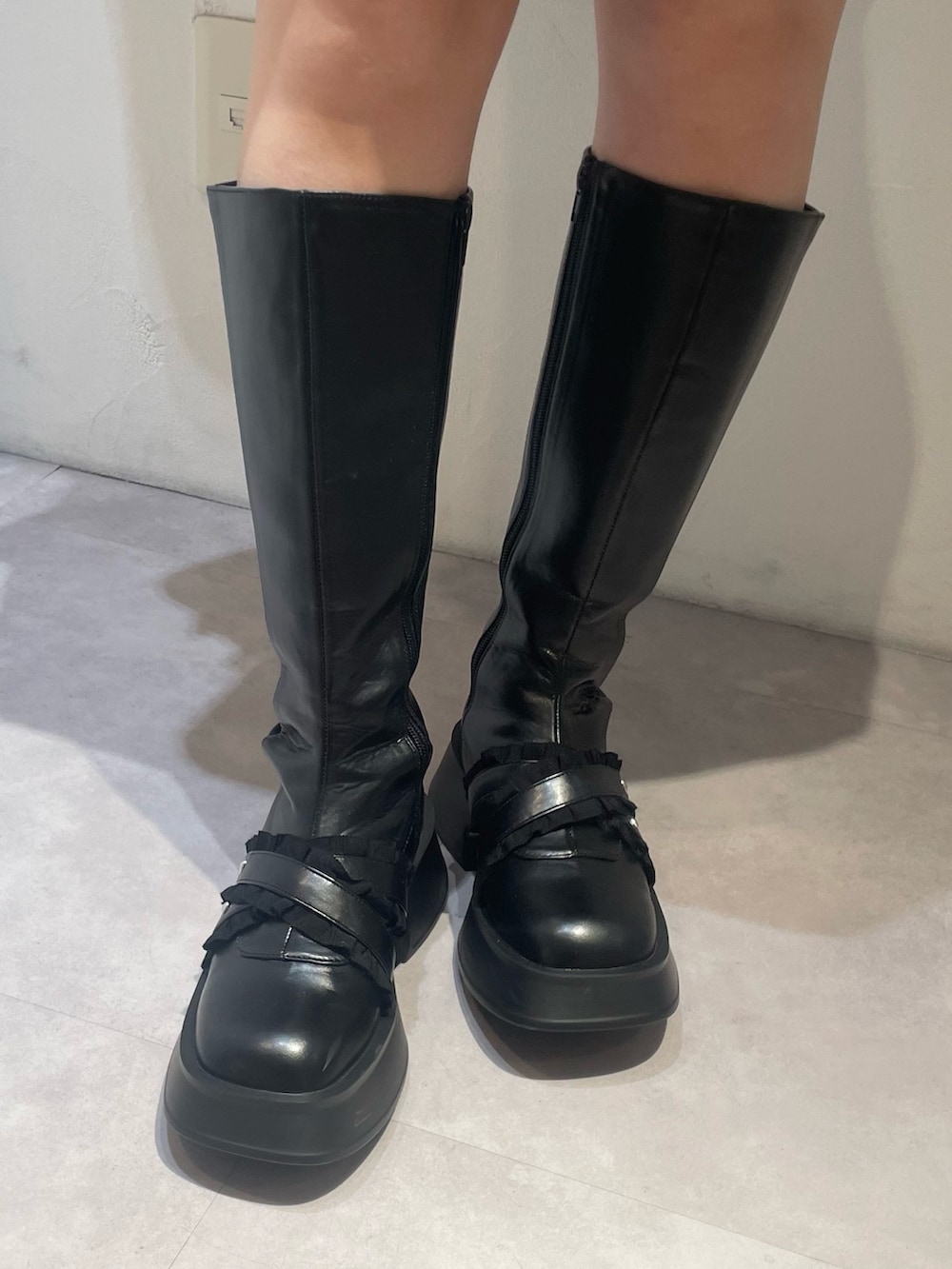 ブラック系のスカート、ブルー系のカーディガン/ボレロ、ブラック系のブーツを着用したレディースの冬コーディネートの7枚目の写真