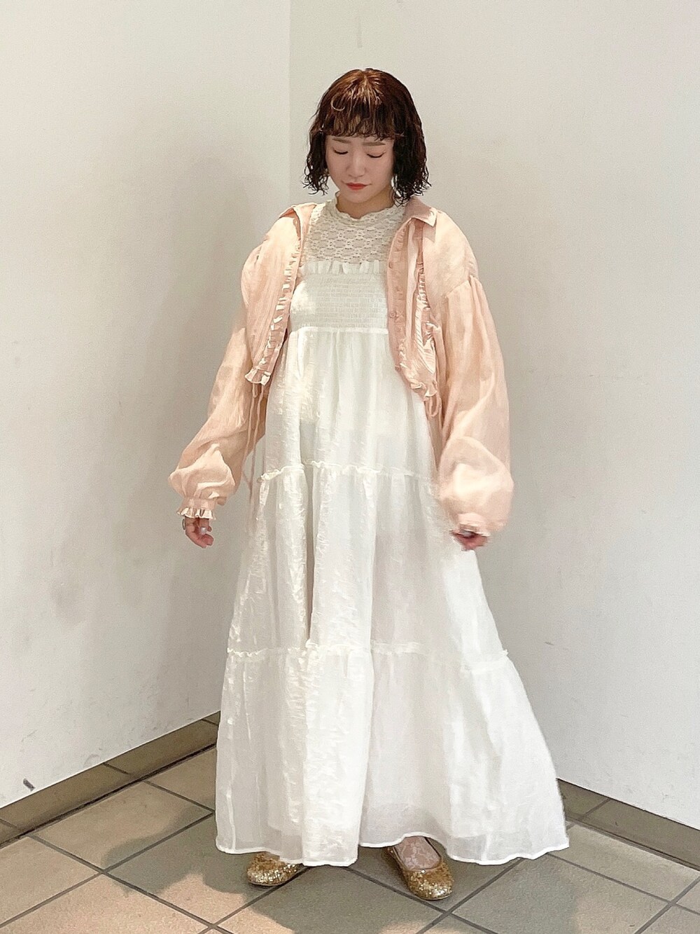 ホワイト系のワンピース、ピンク系のシャツ/ブラウス、ゴールド系のパンプスを着用したレディースの春コーディネートの2枚目の写真