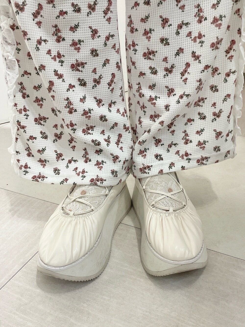 ホワイト系のバレエシューズ、レッド系のスウェットパンツ、ホワイト系のショルダーバッグを着用したレディースの冬コーディネートの8枚目の写真