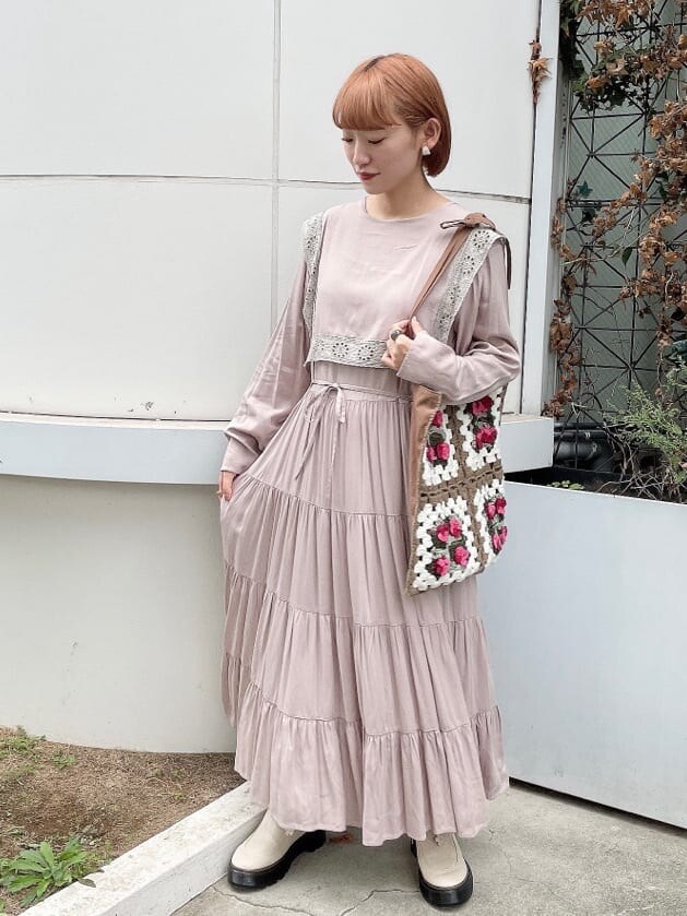 ホワイト系のブーツ、ピンク系のワンピース、ブラウン系のハンドバッグを着用したレディースの秋コーディネートの2枚目の写真