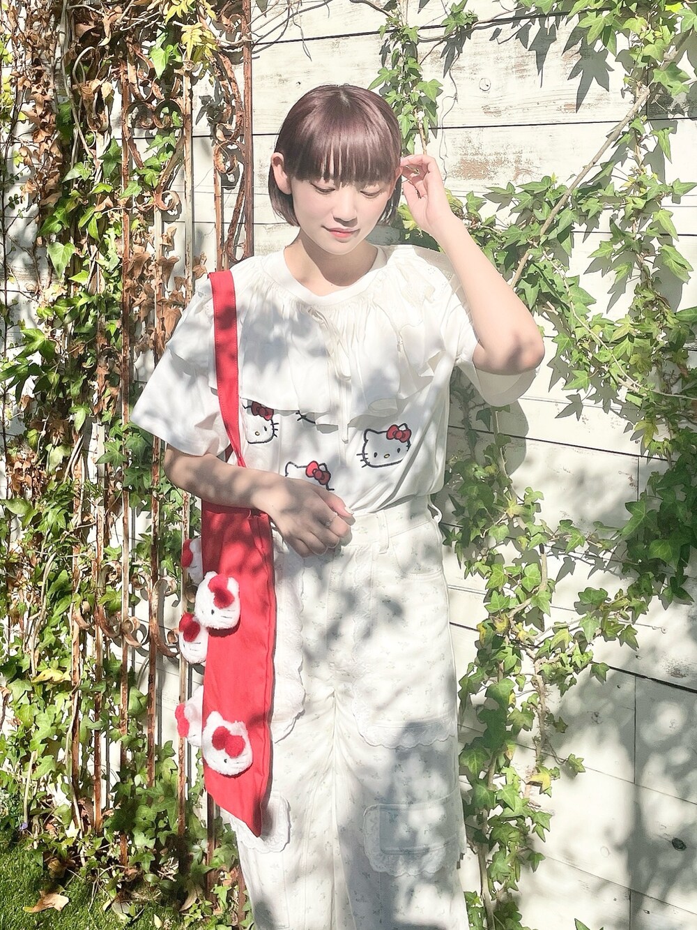 ホワイト系のスニーカー、ホワイト系のカーゴパンツ、レッド系のトートバッグを着用したレディースの春コーディネートの4枚目の写真