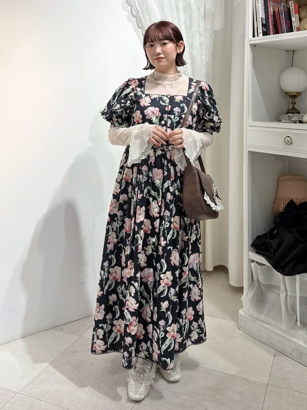 ホワイト系のTシャツ/カットソー、ブラック系のワンピース、ブラウン系のショルダーバッグを着用したレディースの春コーディネートの2枚目の写真