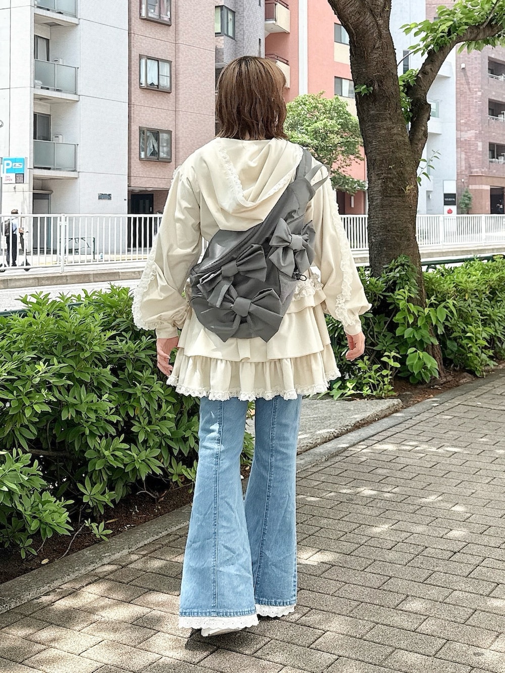 ブルー系のデニムパンツ、ホワイト系のスカート、ホワイト系のパーカーを着用したレディースの春コーディネートの3枚目の写真
