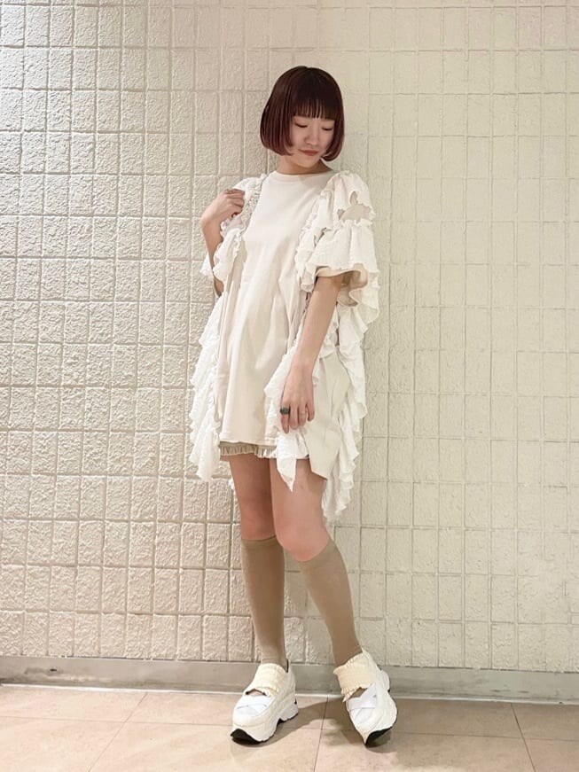 ホワイト系のチュニック、ホワイト系のその他パンツ、ゴールド系のショルダーバッグを着用したレディースの春コーディネートの3枚目の写真