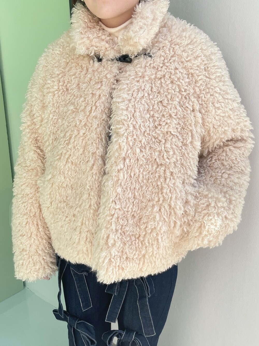 ホワイト系のダウンジャケット/コート、ブルー系のデニムパンツ、ホワイト系のスニーカーを着用したレディースの冬コーディネートの6枚目の写真