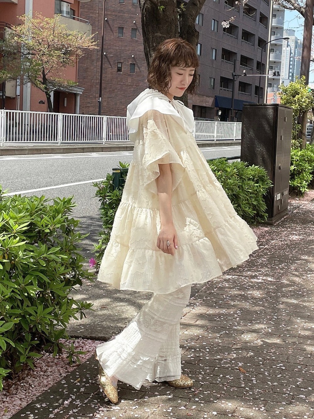 ホワイト系のワンピース、ホワイト系のスラックス、ゴールド系のパンプスを着用したレディースの春コーディネートの2枚目の写真