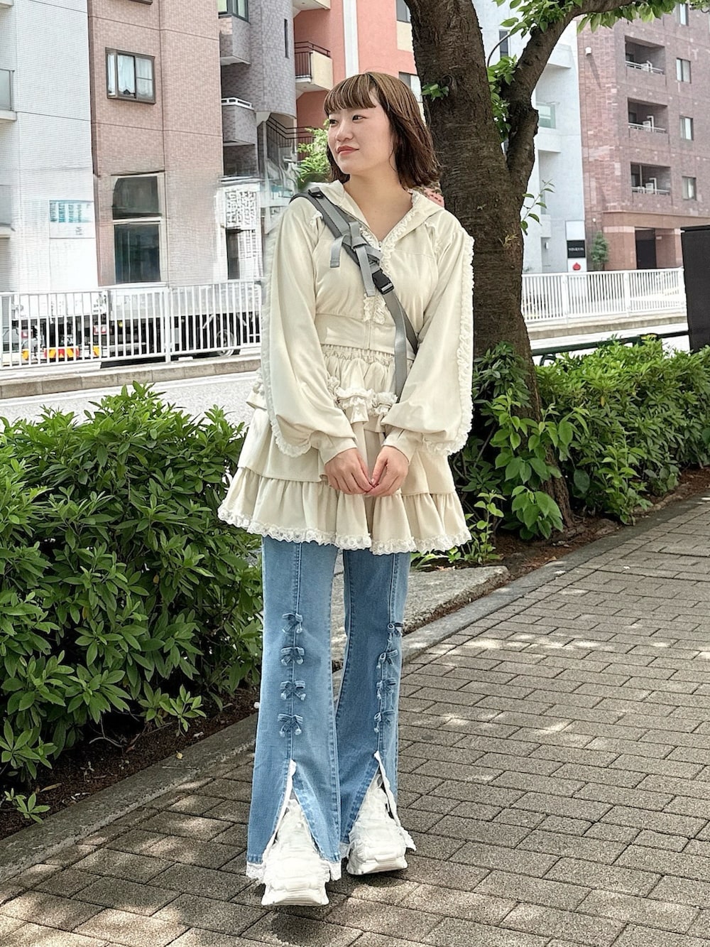 ブルー系のデニムパンツ、ホワイト系のスカート、ホワイト系のパーカーを着用したレディースの春コーディネートの2枚目の写真