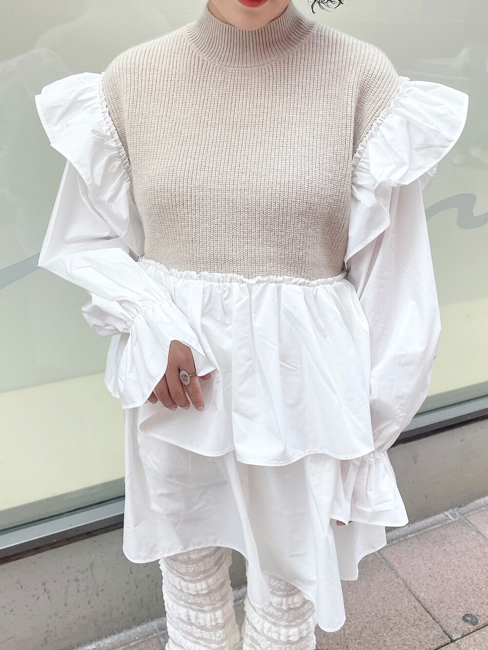 ベージュ系のワンピース、ホワイト系のスニーカー、ホワイト系のスウェットパンツを着用したレディースの秋コーディネートの5枚目の写真