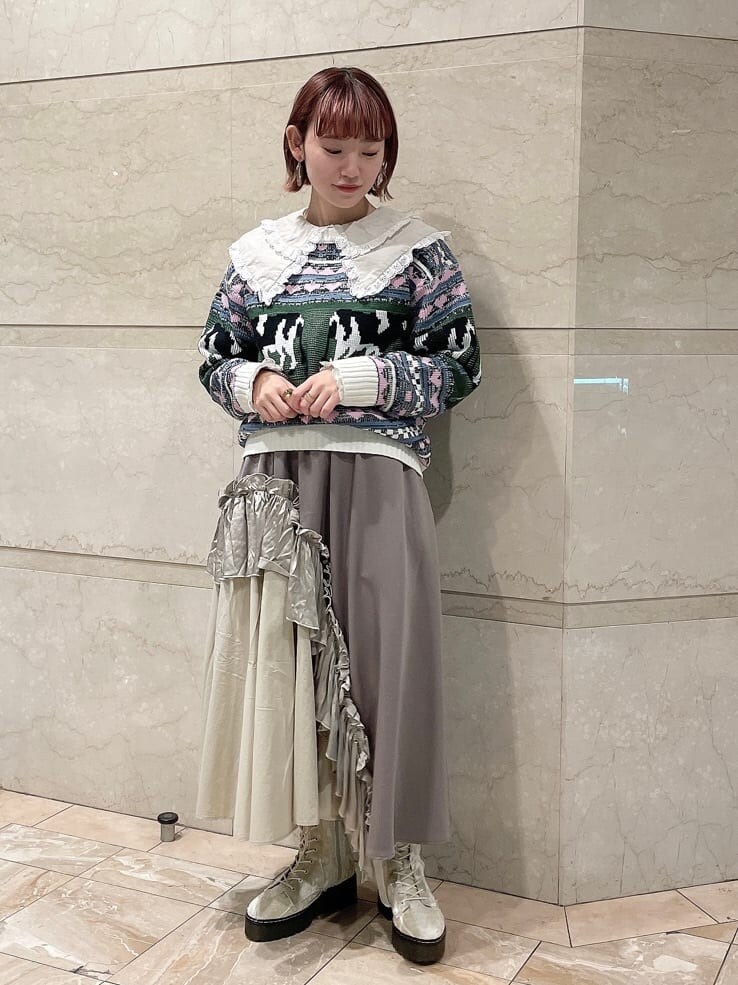 ホワイト系のニット/セーター、ベージュ系のスカート、ホワイト系のブーツを着用したレディースの秋コーディネートの2枚目の写真