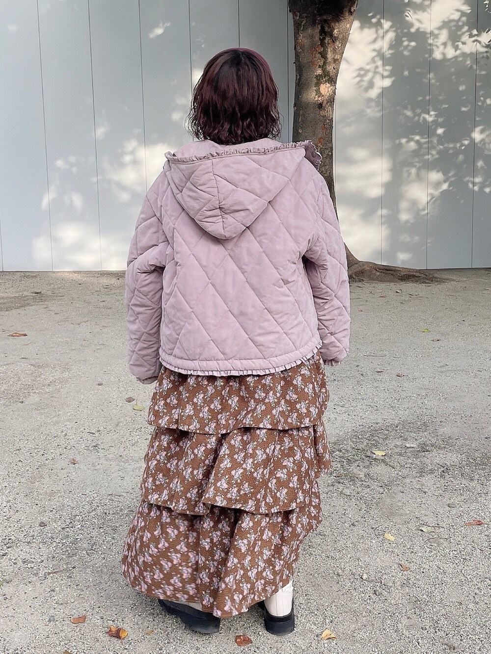 ピンク系のその他アウター、ブラック系のジャンパースカート、ブルー系のニット/セーターを着用したレディースの冬コーディネートの2枚目の写真