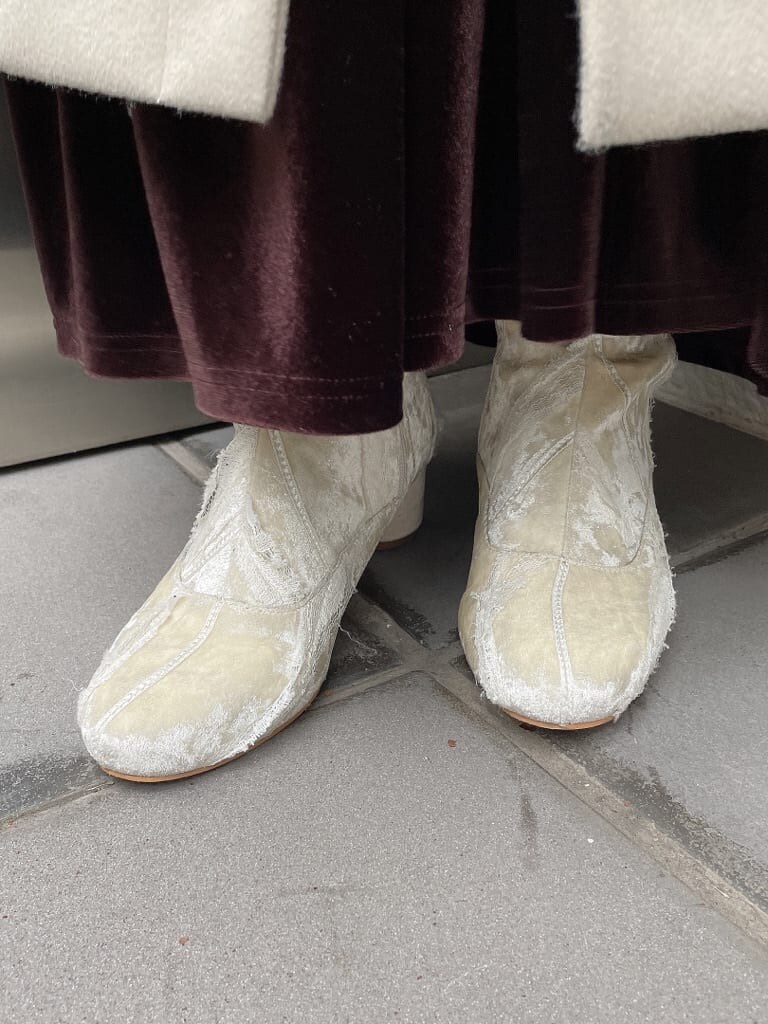 ホワイト系のその他アウター、ホワイト系のニット/セーター、ブラウン系のスカートを着用したレディースの秋コーディネートの4枚目の写真