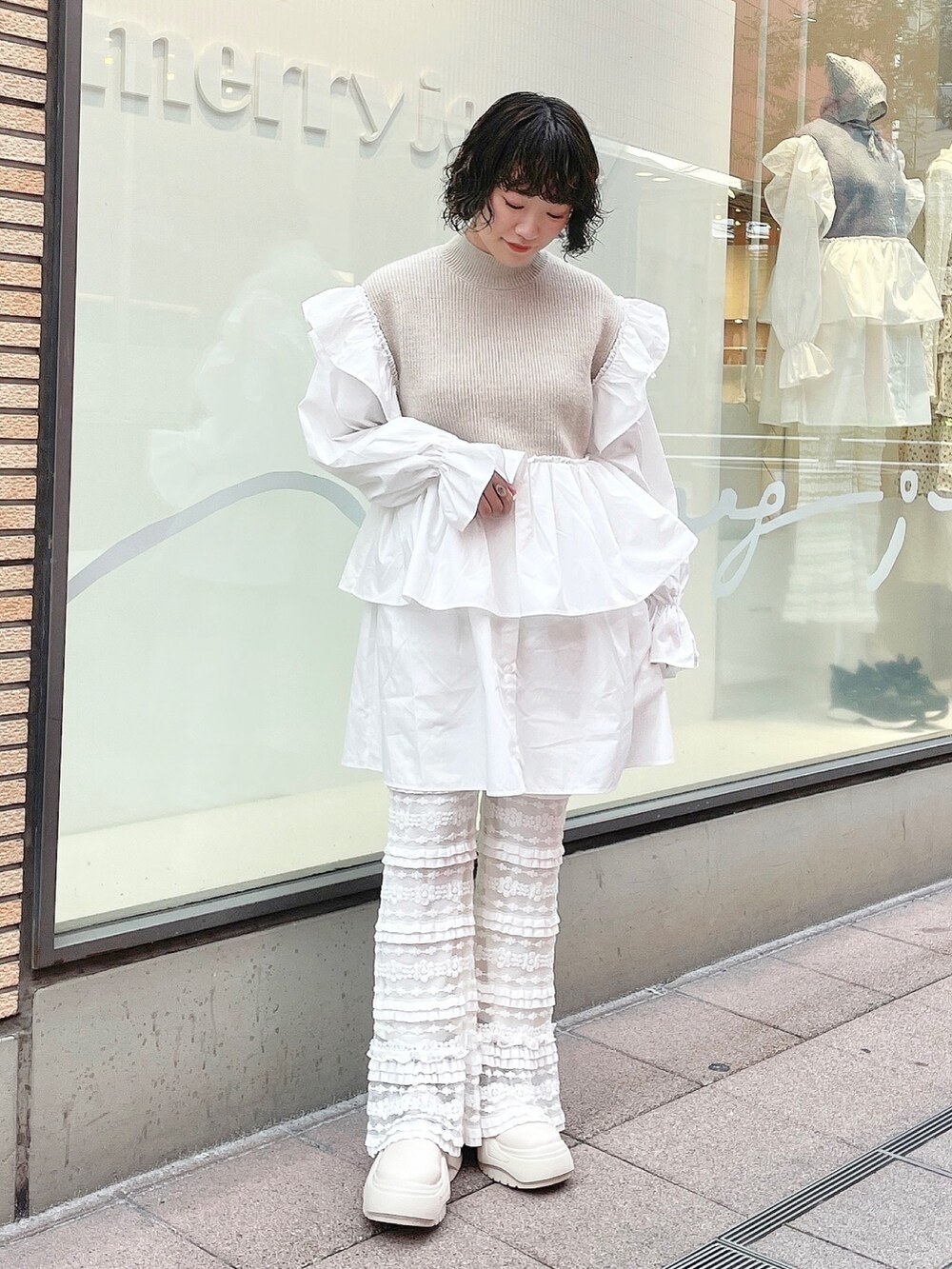 ベージュ系のワンピース、ホワイト系のスニーカー、ホワイト系のスウェットパンツを着用したレディースの秋コーディネートの2枚目の写真