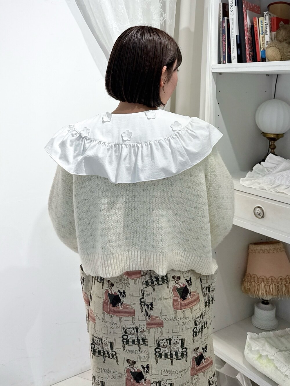ベージュ系のジャンパースカート、ホワイト系のシャツ/ブラウス、ホワイト系のカーディガン/ボレロを着用したレディースの夏コーディネートの7枚目の写真