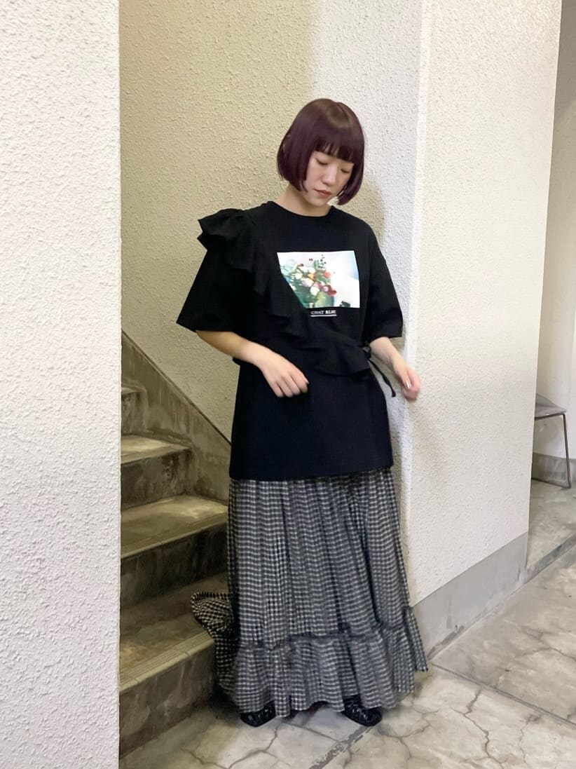 ブラック系のスカート、ブラック系のパンプス、ブラック系のTシャツ/カットソーを着用したレディースの春コーディネートの2枚目の写真