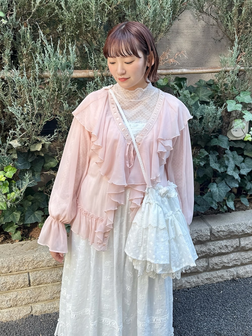 ホワイト系のTシャツ/カットソー、ピンク系のカーディガン/ボレロ、ホワイト系のワンピースを着用したレディースの冬コーディネートの5枚目の写真