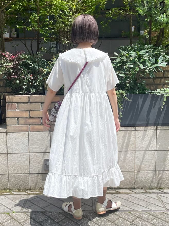 ホワイト系のワンピース、ホワイト系のパンプス、パープル系のハンドバッグを着用したレディースの夏コーディネートの3枚目の写真