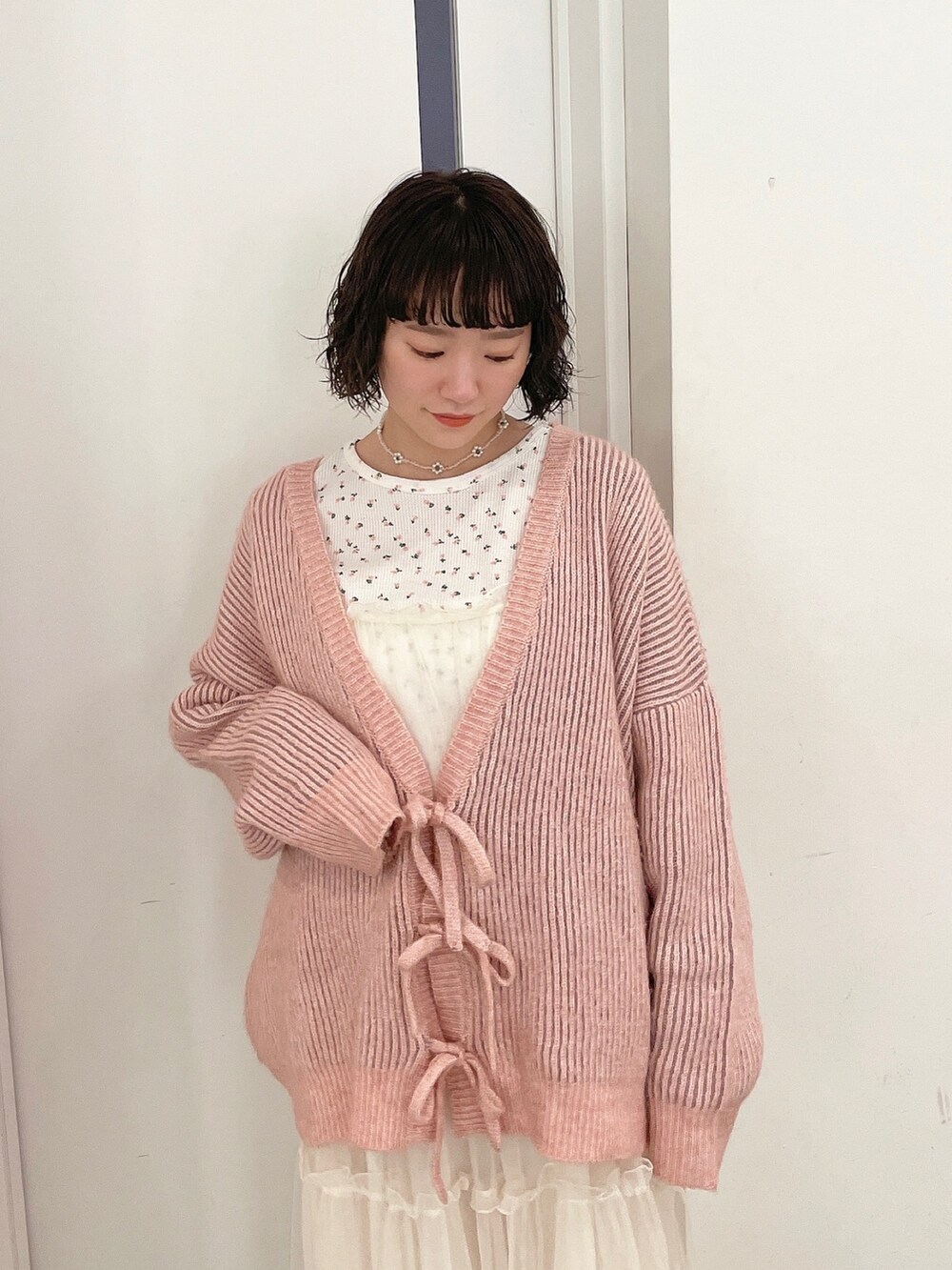 ピンク系のカーディガン/ボレロ、ピンク系のTシャツ/カットソー、ホワイト系のワンピースを着用したレディースの秋コーディネートの3枚目の写真