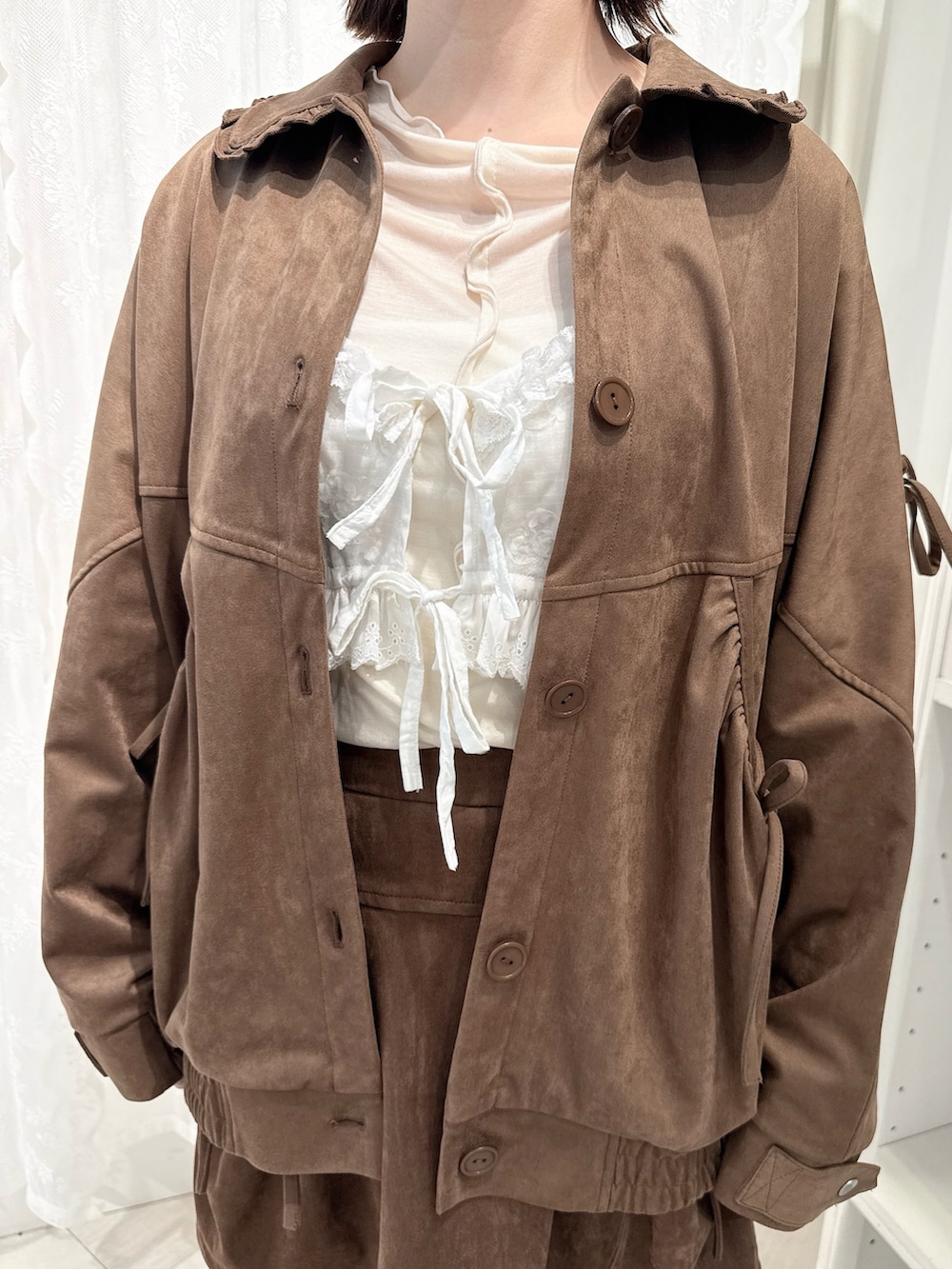 ブラウン系のスカート、ホワイト系のTシャツ/カットソー、ブラウン系のライダースジャケットを着用したレディースの夏コーディネートの6枚目の写真