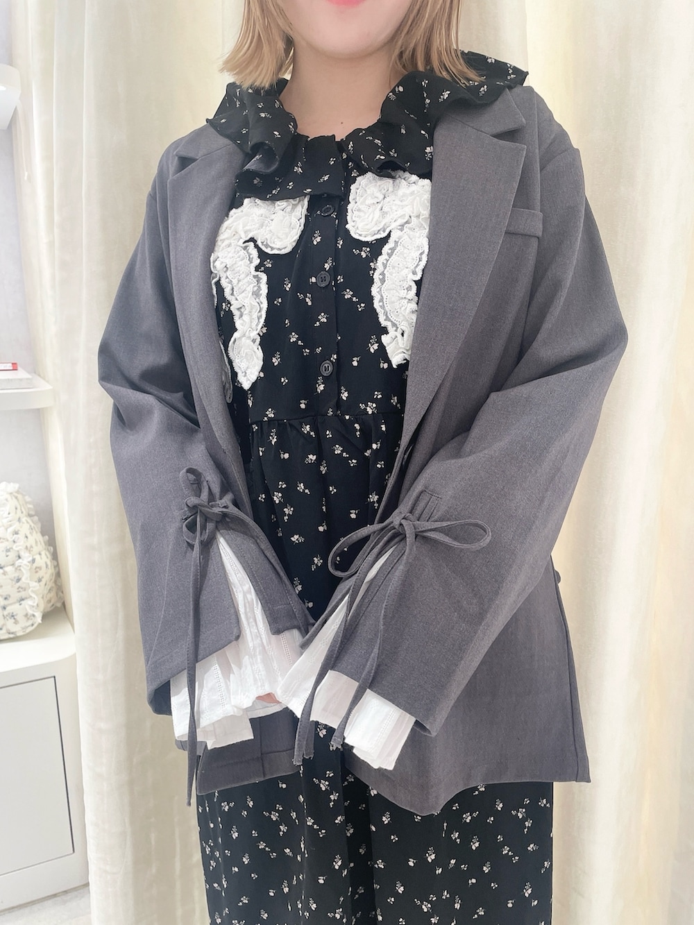 ブラック系のワンピース、グレー系のテーラードジャケット、ブラック系のスニーカーを着用したレディースの冬コーディネートの5枚目の写真