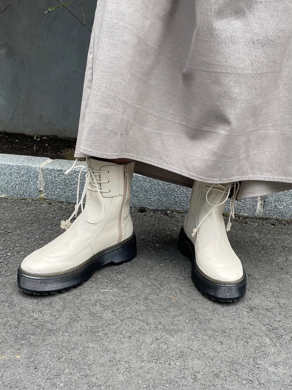 ホワイト系のブーツ、ブラウン系のスカート、ブラック系のトートバッグを着用したレディースの秋コーディネートの5枚目の写真