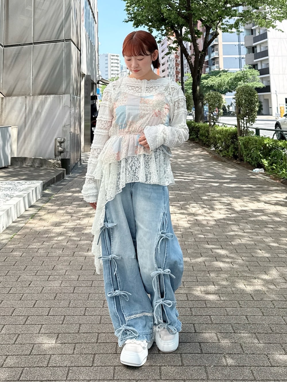 ホワイト系のTシャツ/カットソー、ピンク系のキャミソール、ブルー系のデニムパンツを着用したレディースの春コーディネートの2枚目の写真