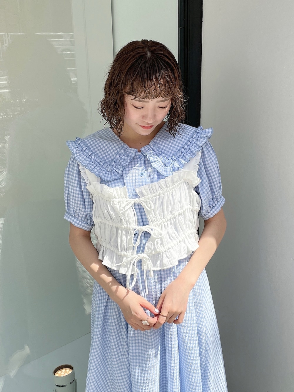 ブルー系のワンピース、ホワイト系のハンドバッグ、ホワイト系のベストを着用したレディースの春コーディネートの5枚目の写真