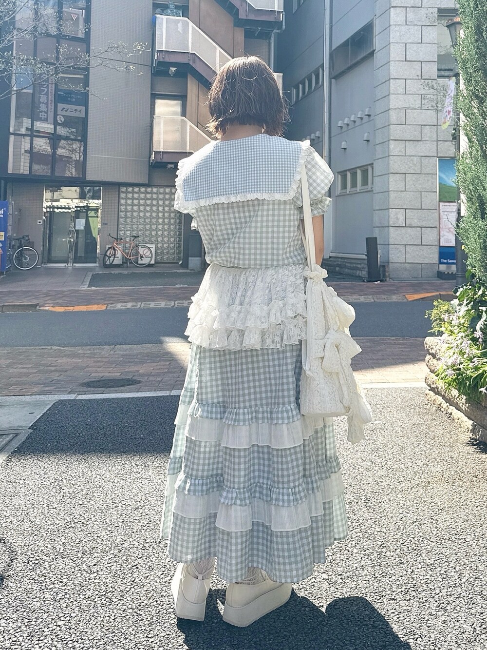 グリーン系のスカート、グリーン系のシャツ/ブラウス、ホワイト系のトートバッグを着用したレディースの春コーディネートの3枚目の写真