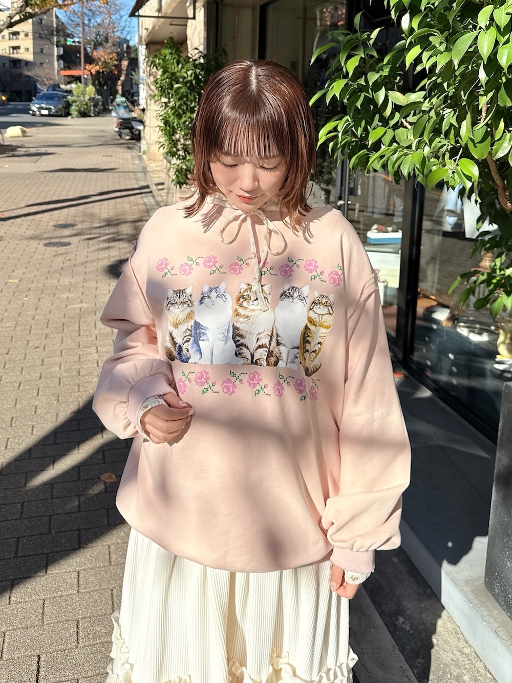 ピンク系のスウェット、ホワイト系のTシャツ/カットソー、ホワイト系のスカートを着用したレディースの冬コーディネートの5枚目の写真