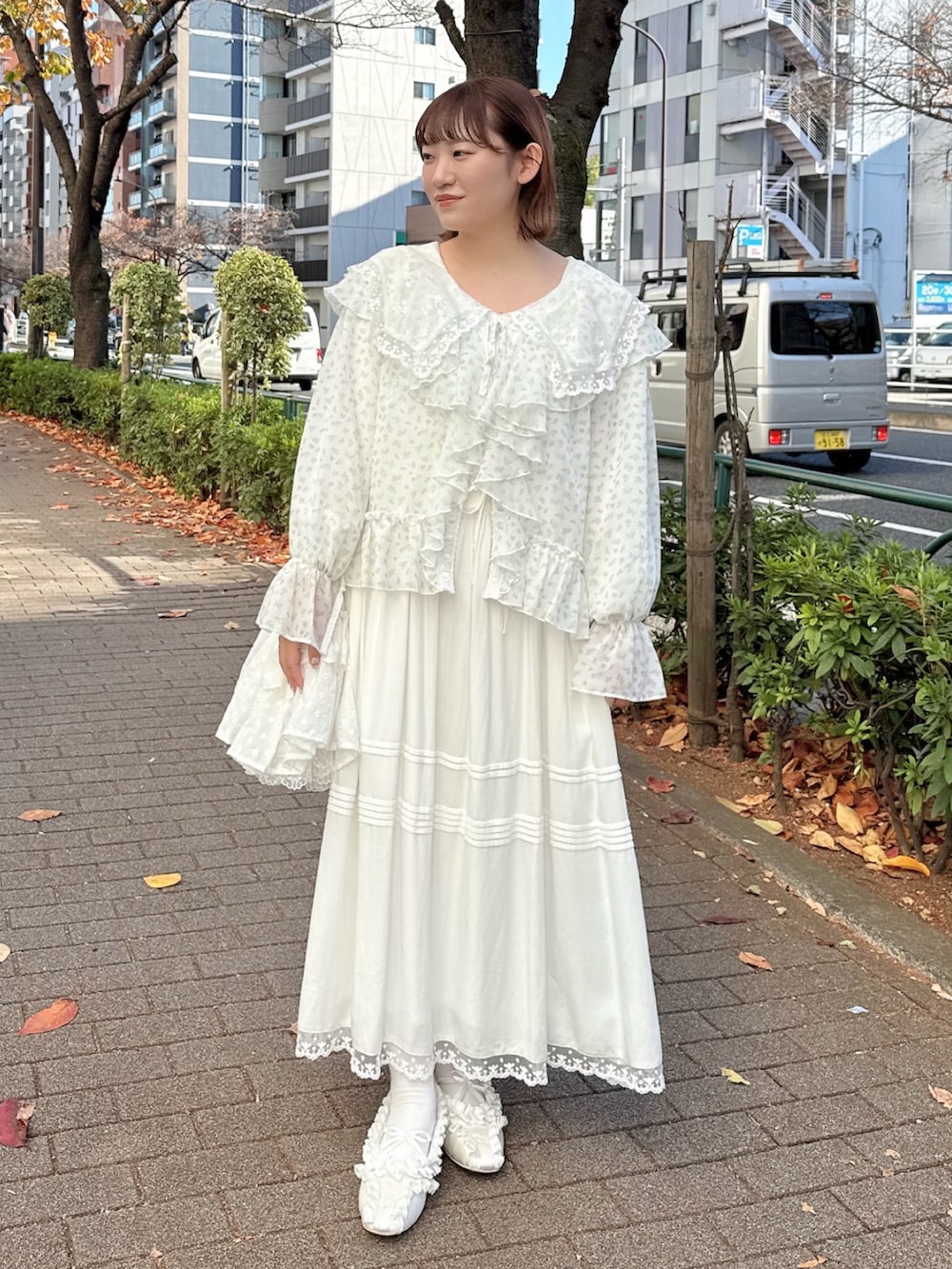 ホワイト系のワンピース、ブルー系のカーディガン/ボレロ、ホワイト系のショルダーバッグを着用したレディースの冬コーディネートの2枚目の写真