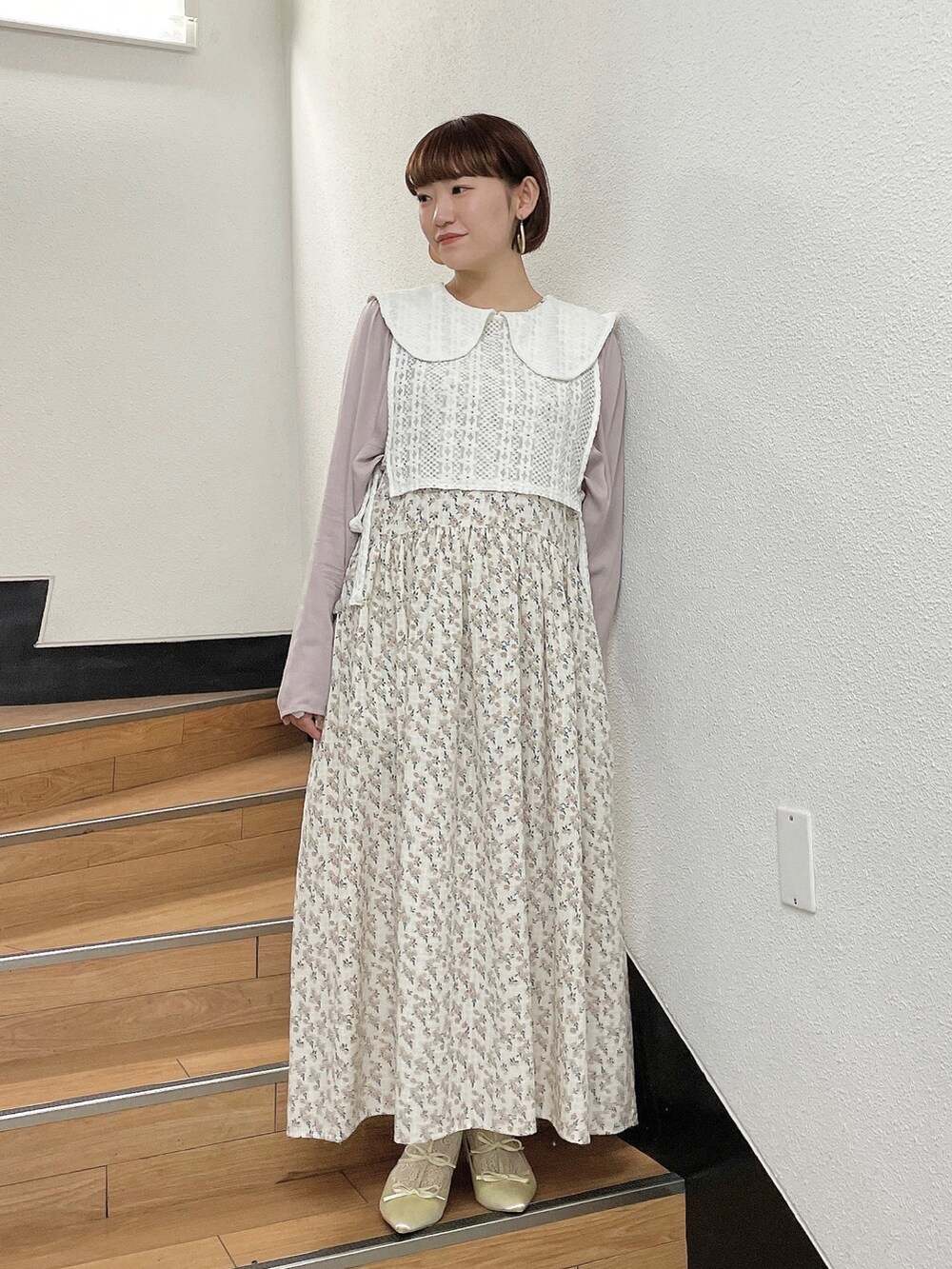 ホワイト系のワンピース、ホワイト系のベスト、ホワイト系のパンプスを着用したレディースの秋コーディネートの2枚目の写真