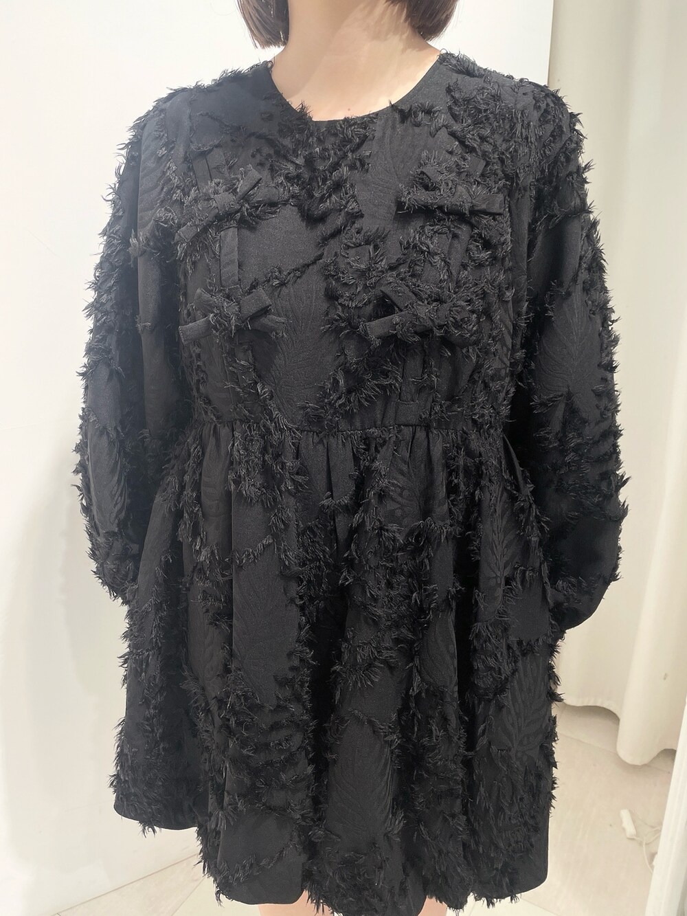 ホワイト系のブルゾン、ブラック系のワンピース、ホワイト系のローファーを着用したレディースの秋コーディネートの9枚目の写真