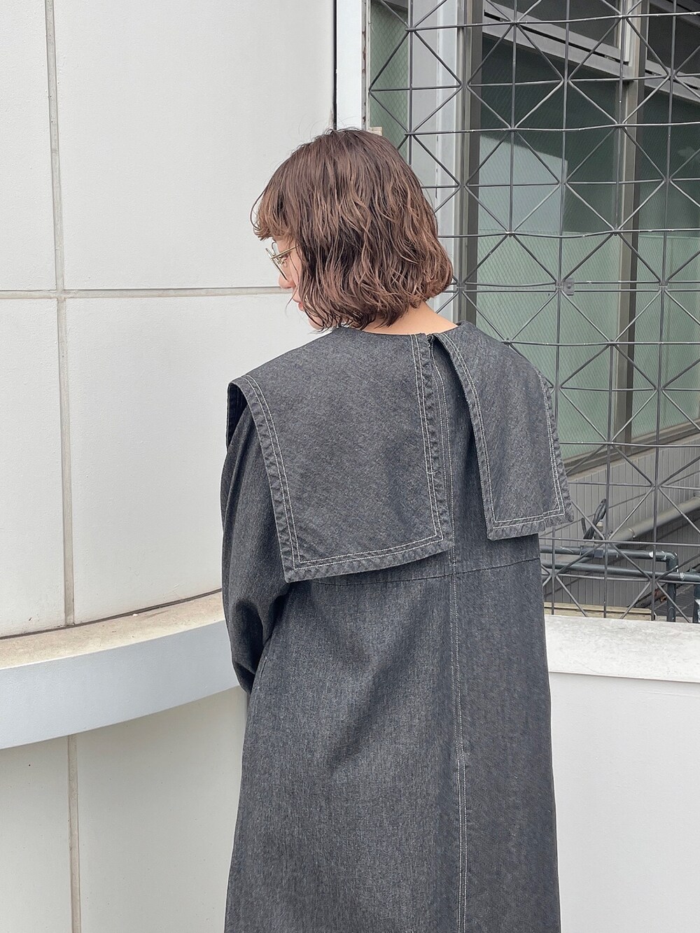 ブラック系のワンピース、ベージュ系のブーツを着用したレディースの冬コーディネートの5枚目の写真