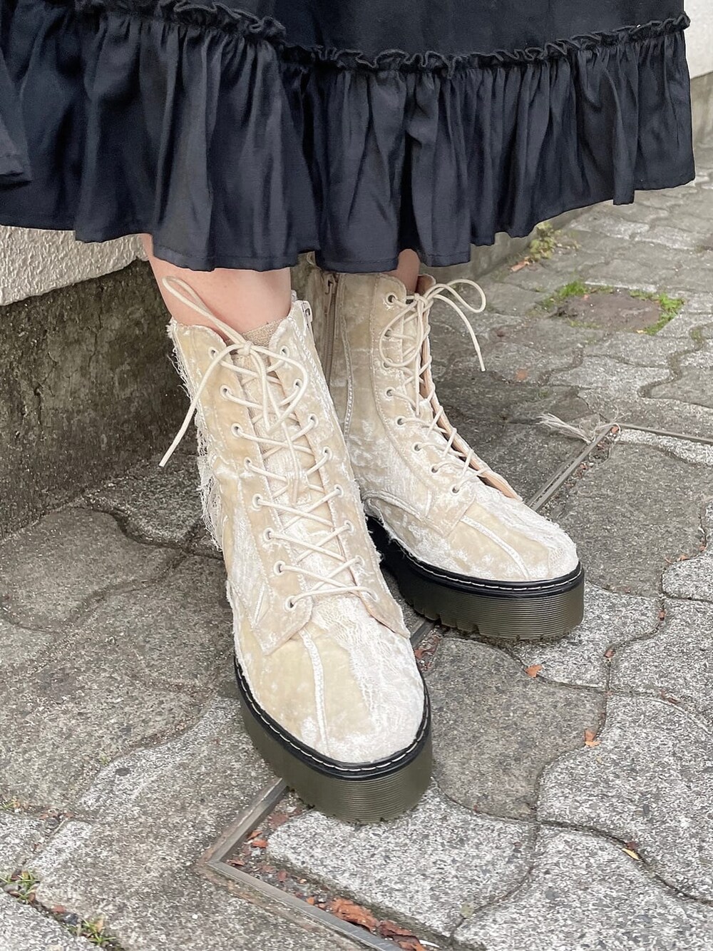 ブラック系のワンピース、ホワイト系のブーツ、レッド系のニット/セーターを着用したレディースの秋コーディネートの3枚目の写真