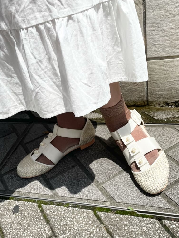 ホワイト系のワンピース、ホワイト系のパンプス、パープル系のハンドバッグを着用したレディースの夏コーディネートの6枚目の写真