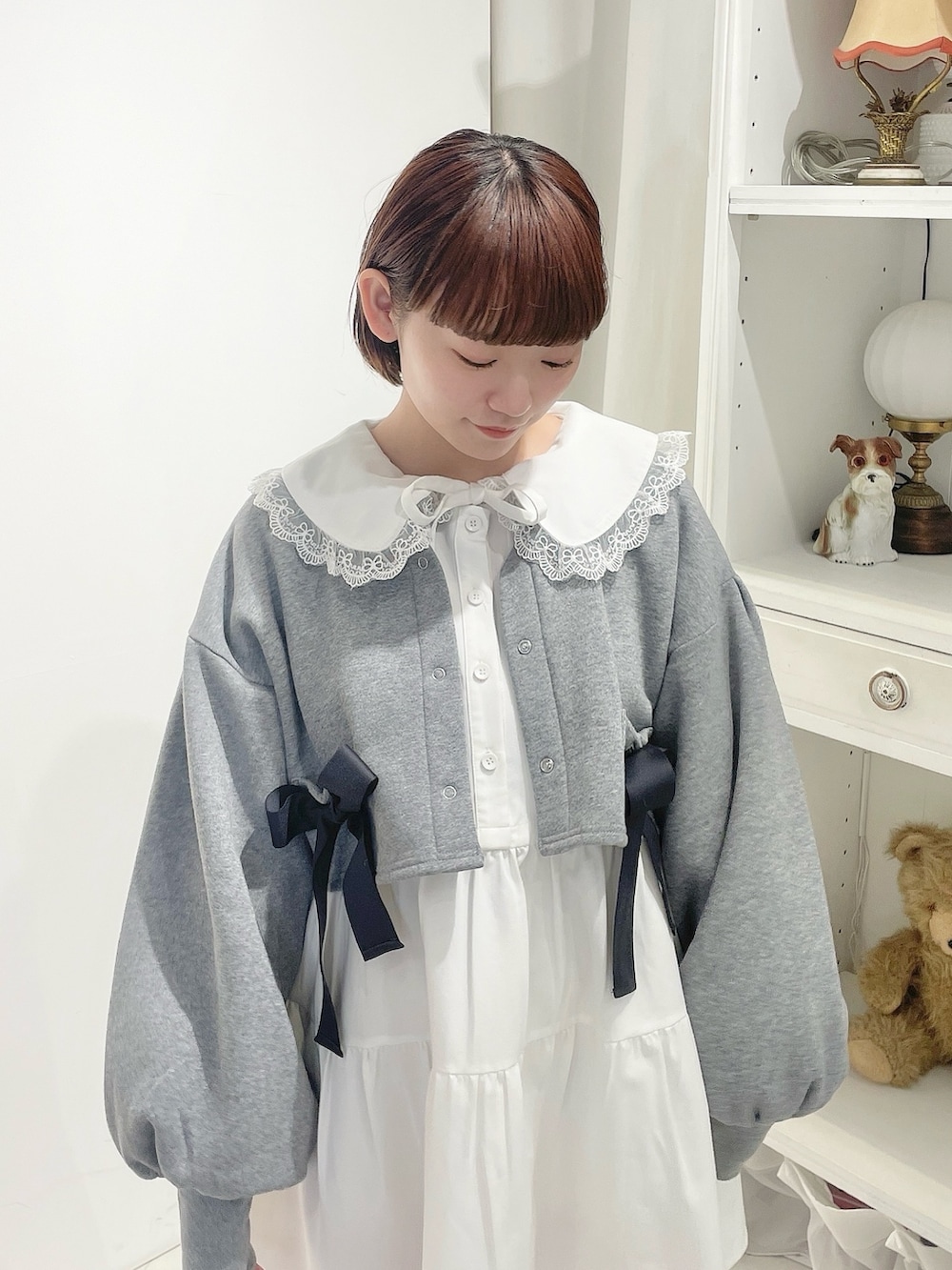 グレー系のカーディガン/ボレロ、ホワイト系のワンピース、ホワイト系のスニーカーを着用したレディースの冬コーディネートの4枚目の写真