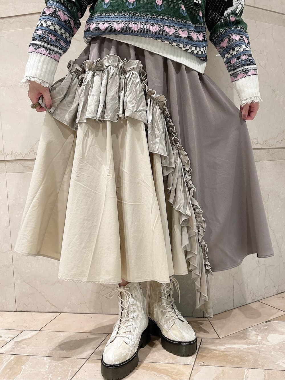 ホワイト系のニット/セーター、ベージュ系のスカート、ホワイト系のブーツを着用したレディースの秋コーディネートの5枚目の写真