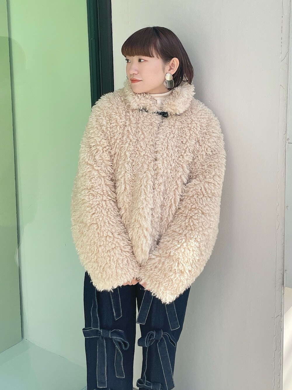 ホワイト系のダウンジャケット/コート、ブルー系のデニムパンツ、ホワイト系のスニーカーを着用したレディースの冬コーディネートの5枚目の写真