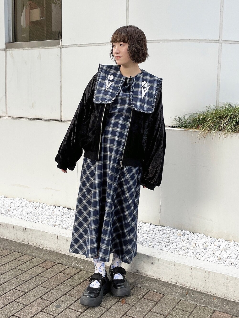 ブルー系のワンピース、ブラック系のブルゾン、ブラック系のスニーカーを着用したレディースの秋コーディネートの2枚目の写真