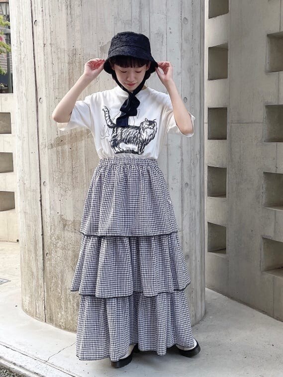 ホワイト系のドレスシューズ、ブラック系のスカート、ホワイト系のTシャツ/カットソーを着用したレディースの夏コーディネートの2枚目の写真